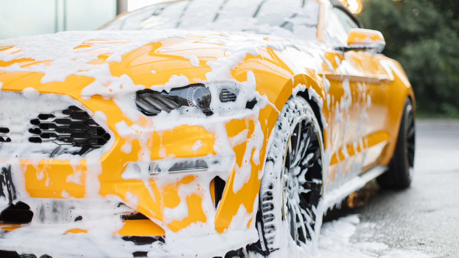 Yellow car covered in wash foam