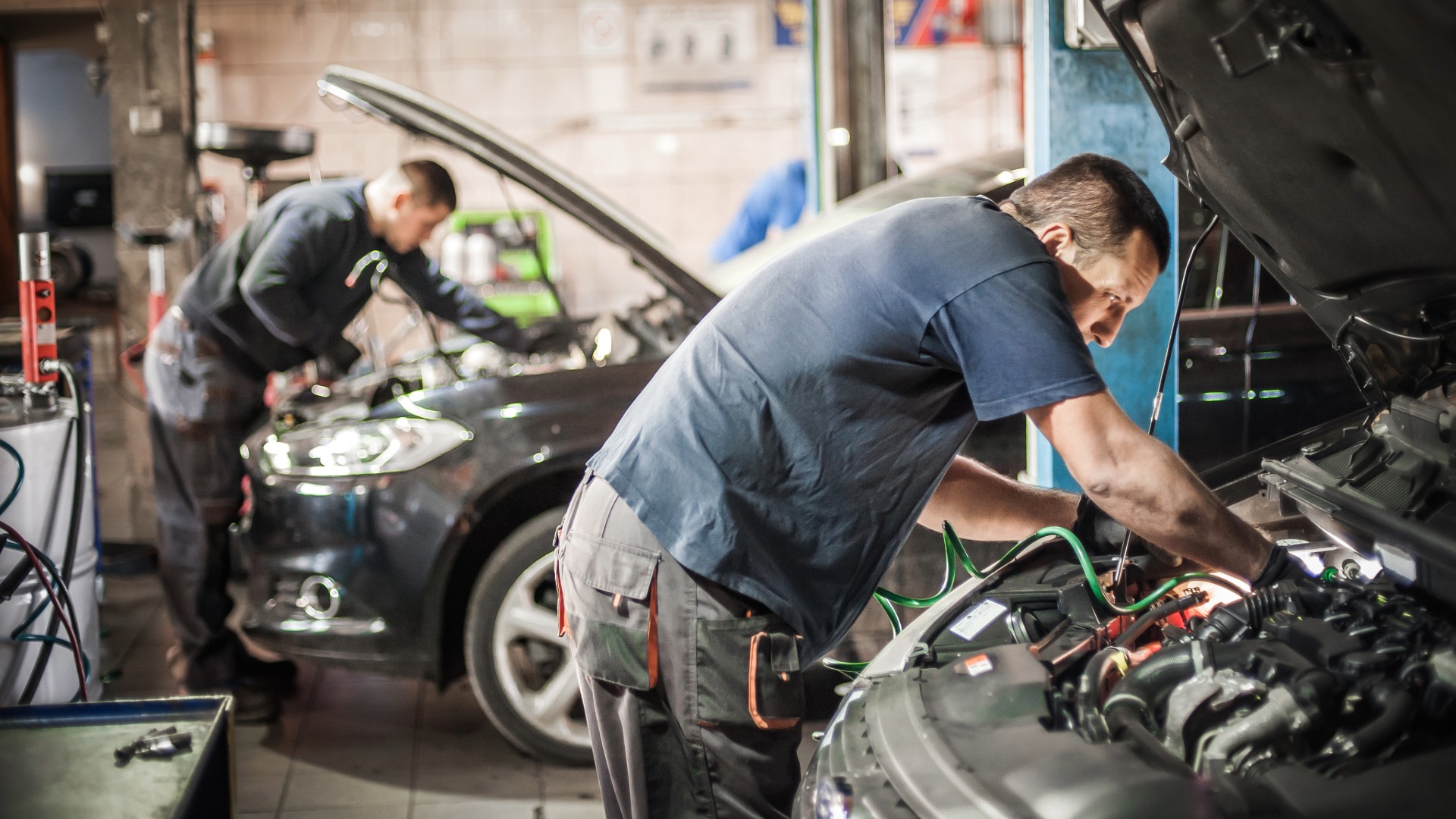 Mechanics working on cars in a garage